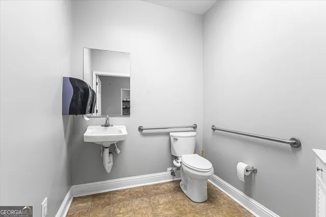 a bathroom with a toilet a sink and mirror