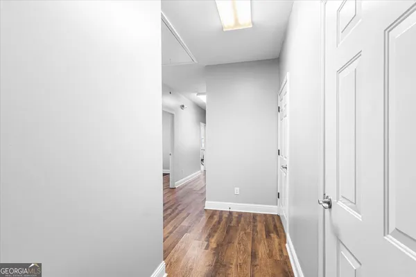 a view of a room with wooden floor and a bathroom