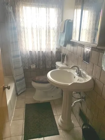 a bathroom with a sink a toilet and a window