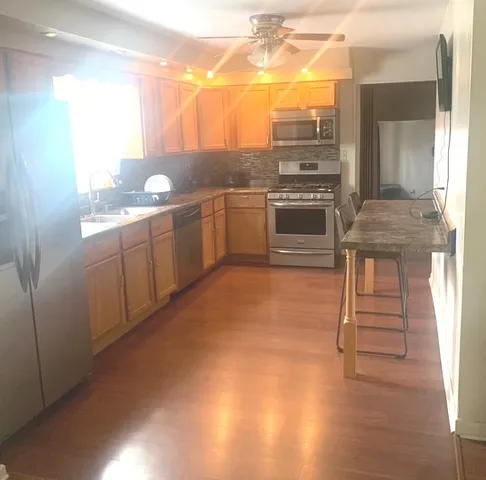 a kitchen with cabinets and wooden floor