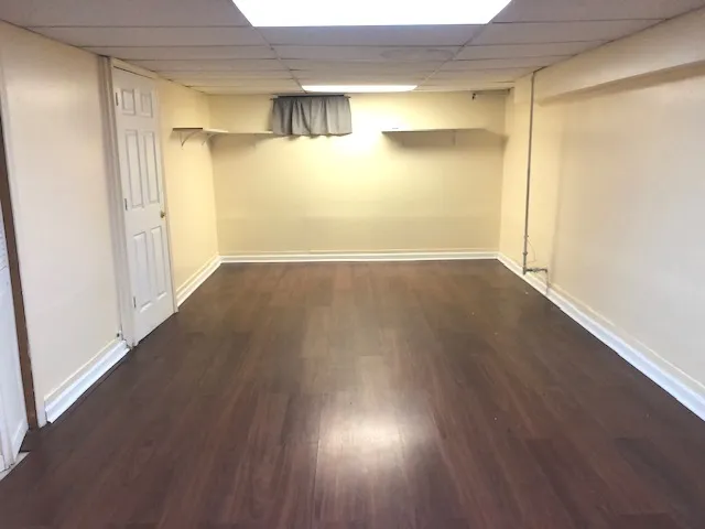 a view of empty room with wooden floor and windows