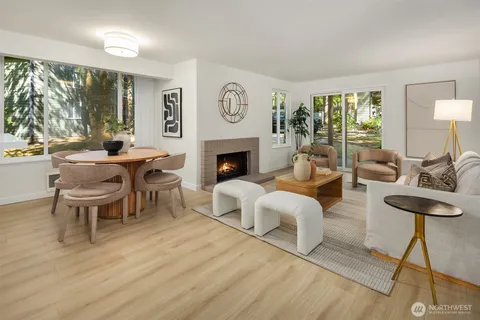 a living room with furniture a fireplace and a large window