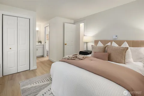 a spacious bedroom with a bed and a lamp