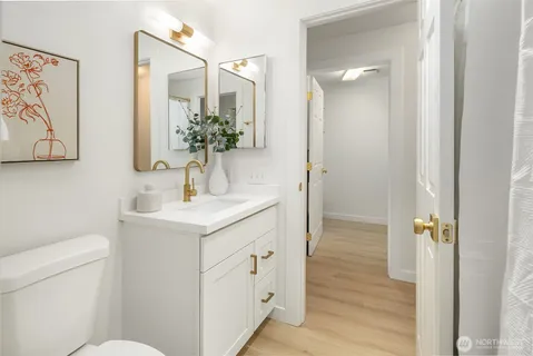 a bathroom with a sink and mirror with toilet