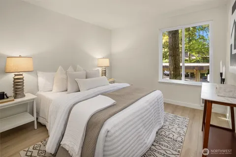 a bedroom with a bed and a lamp on dresser