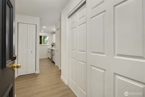 a view of a hallway with bathroom and wooden floor