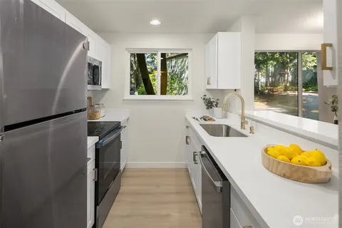 a view of a kitchen with a sink and dishwasher wooden floor