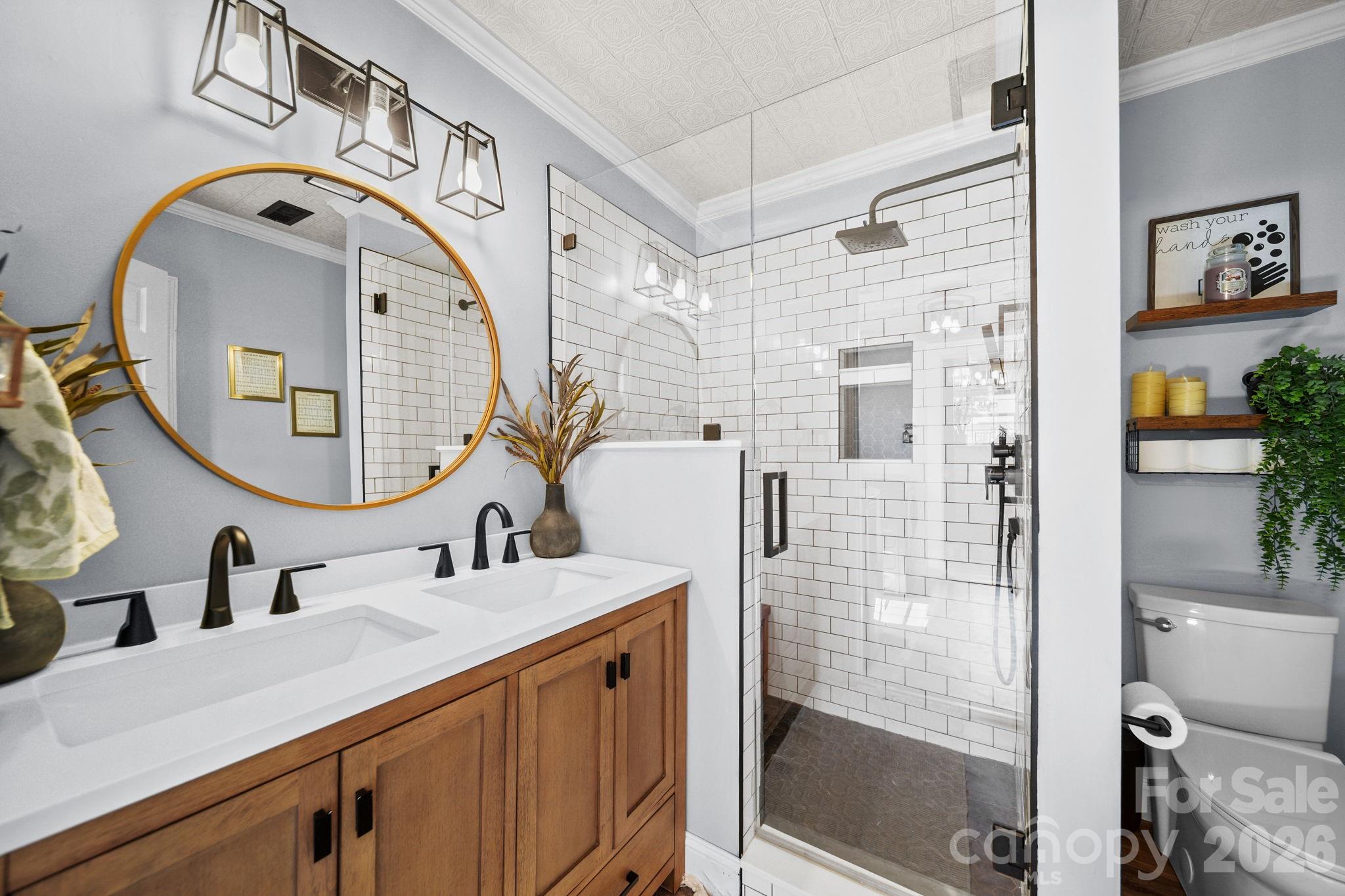 9215 Stokes Ferry Road Salisbury, NC 28146 - Photo 13 of 22 a bathroom with a sink a mirror a vanity and shower