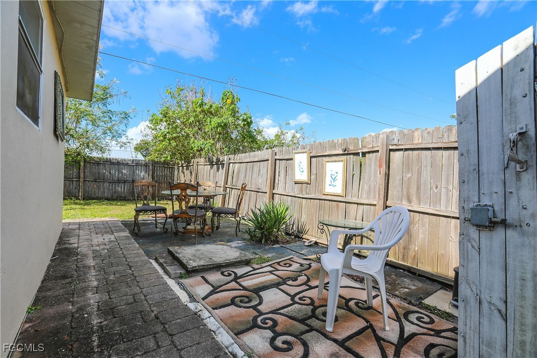 907 Laredo Avenue Lehigh Acres, FL 33936 - Photo 4 of 13 a view of a chairs and table in backyard