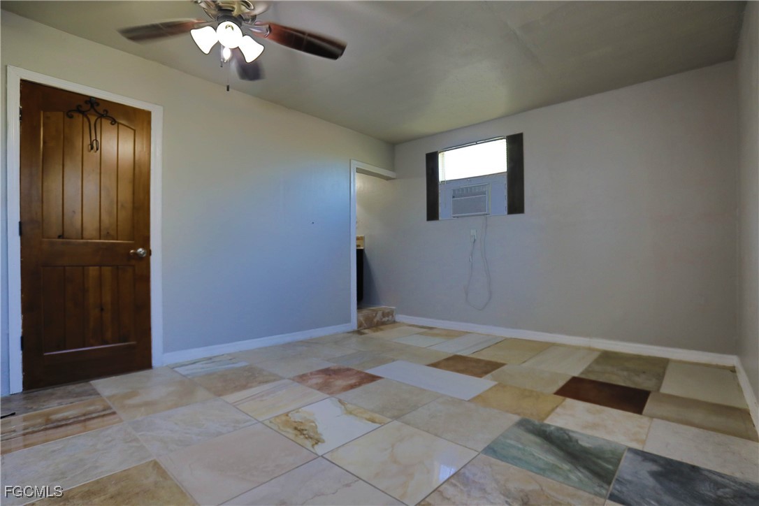 907 Laredo Avenue Lehigh Acres, FL 33936 - Photo 8 of 13 a view of an empty room with window and chandelier fan