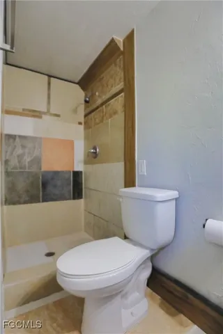 a bathroom with a toilet and a shower