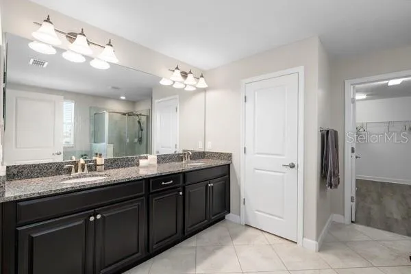 a bathroom with a double vanity sink and a mirror