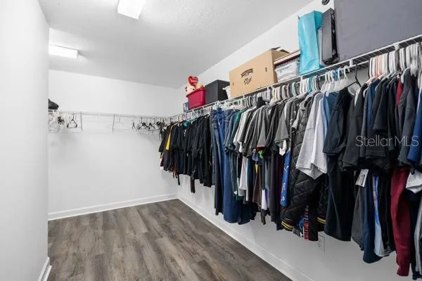 a bed sitting in a spacious bedroom next to a window
