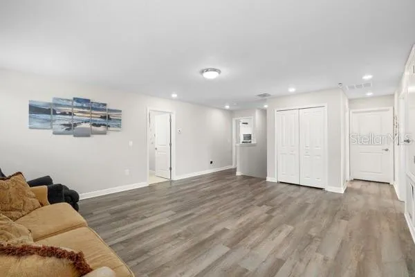 a living room with furniture and a wooden floor