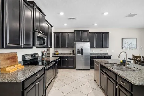 a kitchen with granite countertop stainless steel appliances and sink