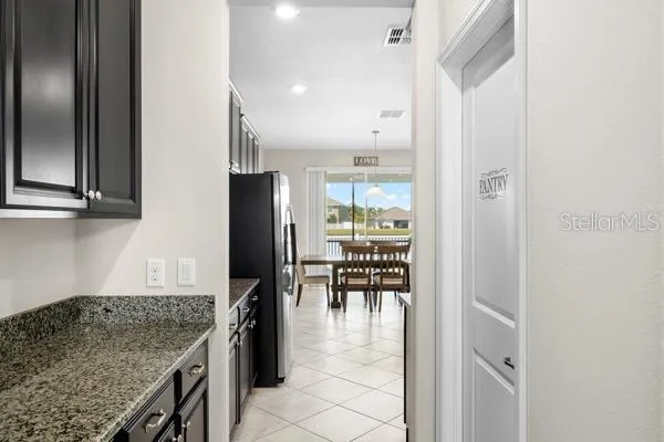 an open kitchen with granite countertop a refrigerator and a sink