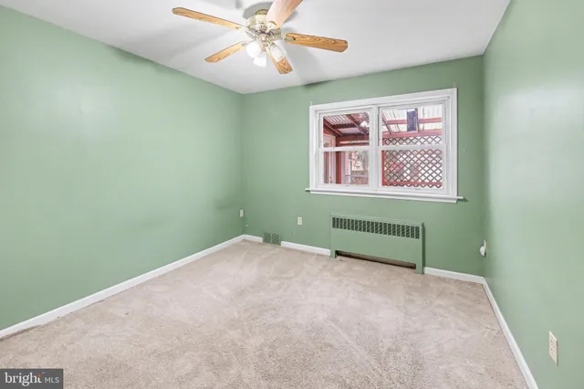 an empty room with a window and a fan