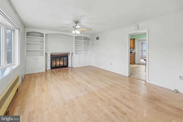 a view of empty room with wooden floor and fireplace