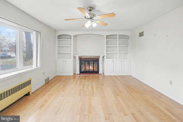 a view of an empty room with a fireplace and a window