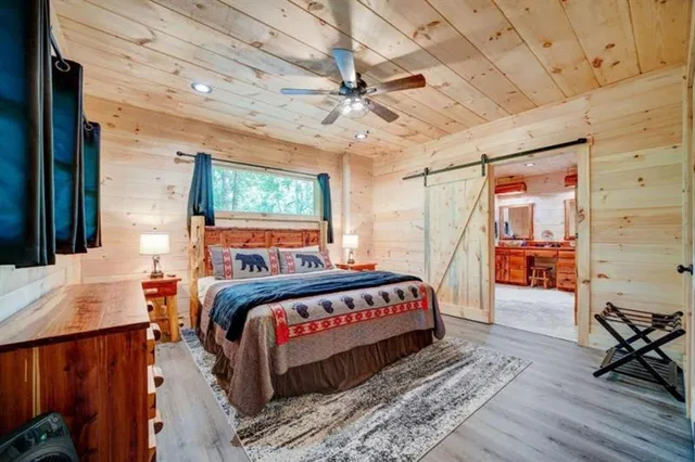 a bedroom with a bed a dresser and flat screen tv