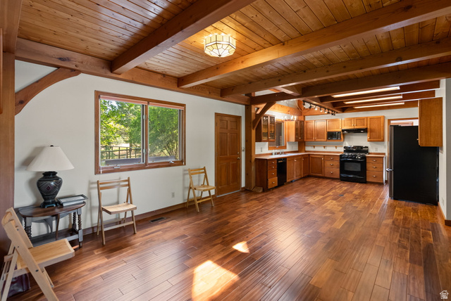 435 Canyon Road Millville, UT 84326 - Photo 14 of 113 Open-concept living space featuring wood-finish flooring, exposed wood beam ceiling, and a kitchen with wood cabinetry