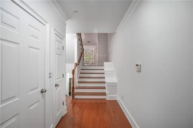 a view of a hallway with wooden floor and entryway