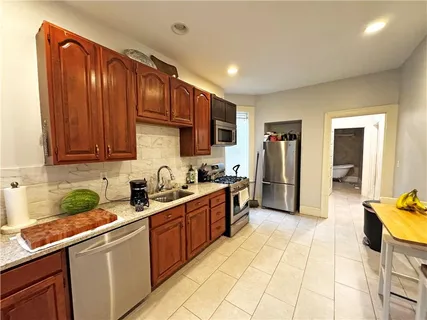 a kitchen with stainless steel appliances granite countertop a sink counter space cabinets and a view of living room