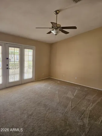 an empty room with windows and fan