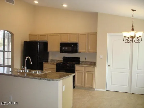 a kitchen with stainless steel appliances granite countertop a sink and a refrigerator