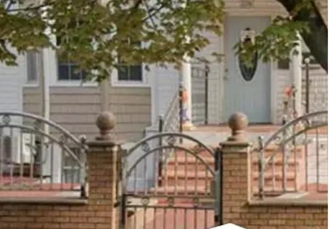 a front view of a house with a tree