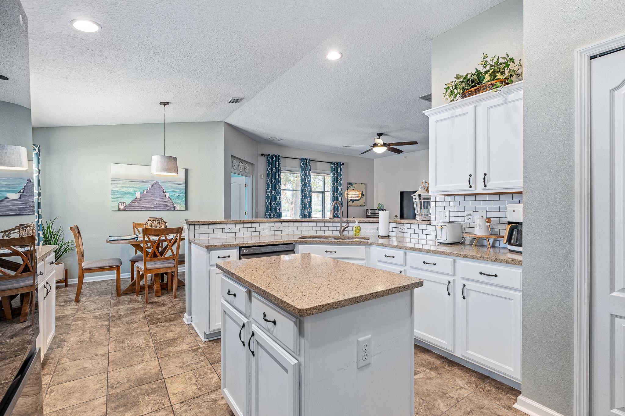 1353 Camp Ridge Lane Middleburg, FL 32068 - Photo 27 of 88 Kitchen featuring white cabinetry, a peninsula, decorative light fixtures, and tasteful backsplash