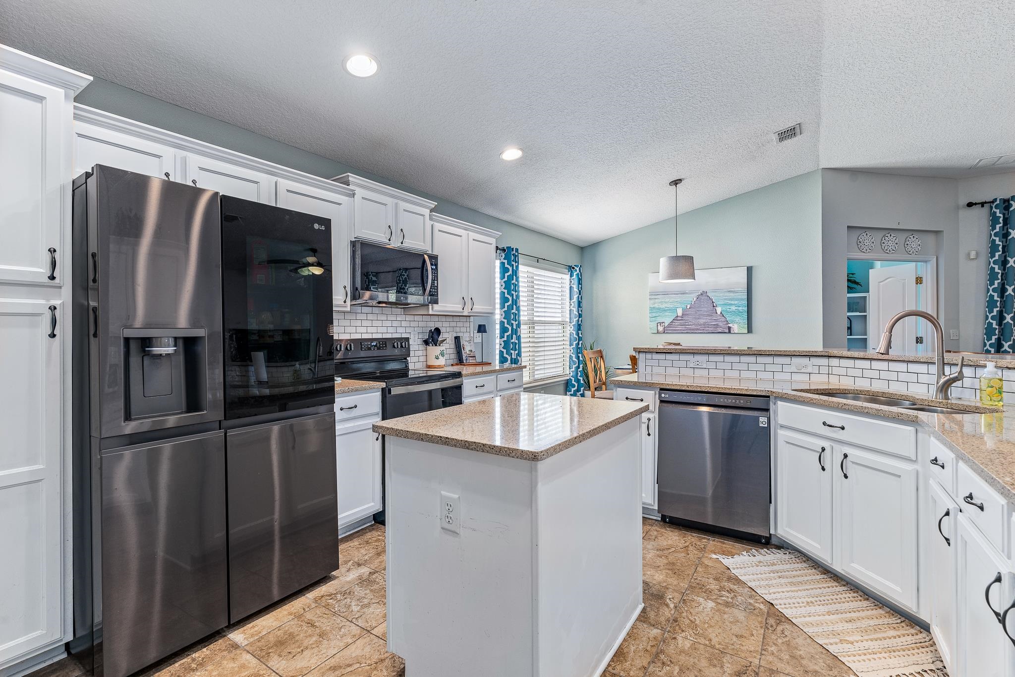 1353 Camp Ridge Lane Middleburg, FL 32068 - Photo 28 of 88 Kitchen featuring stainless steel appliances, white cabinetry, decorative backsplash, and hanging light fixtures