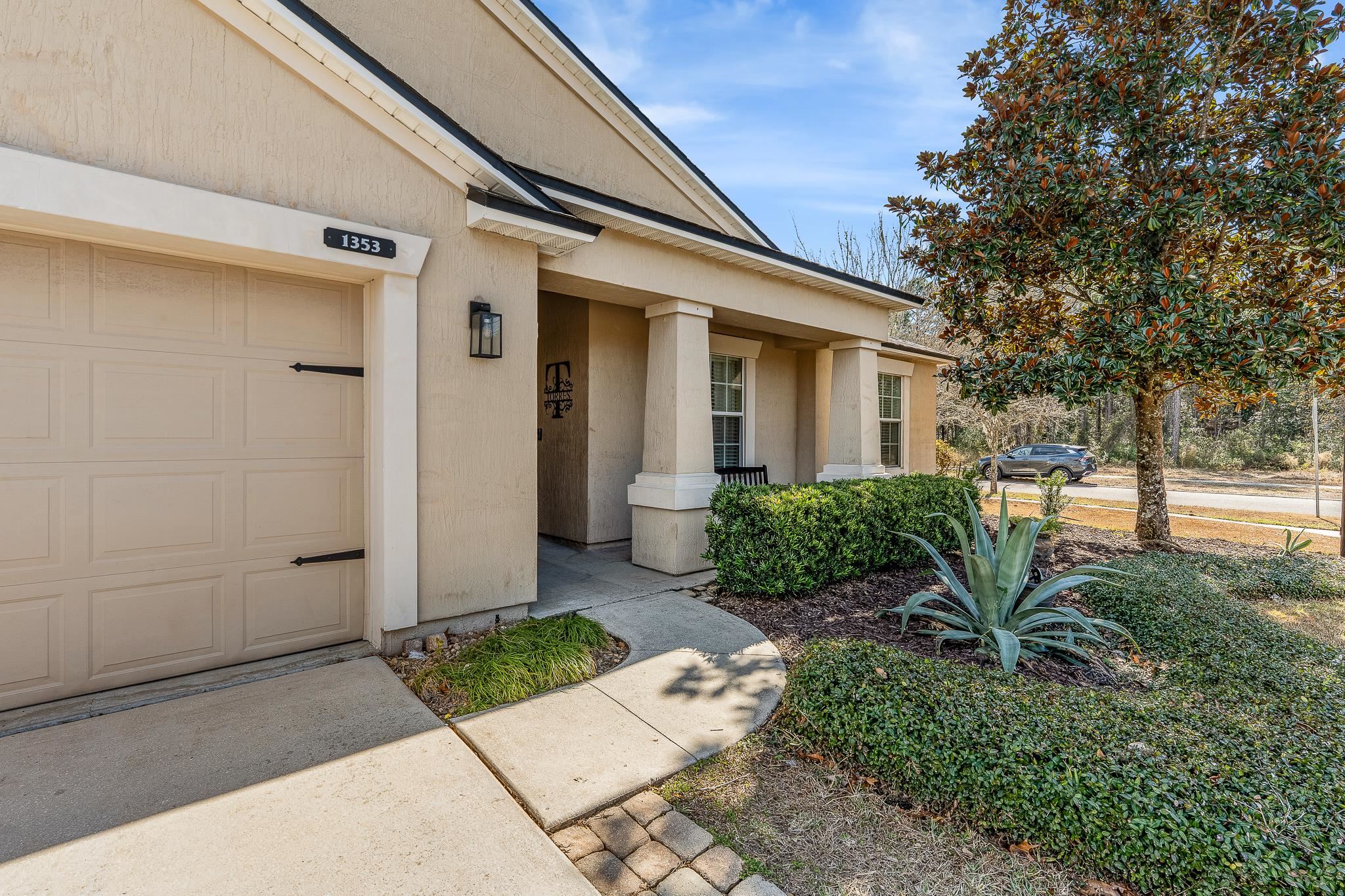1353 Camp Ridge Lane Middleburg, FL 32068 - Photo 3 of 88 View of exterior entry featuring a garage, stucco siding, driveway, and covered porch