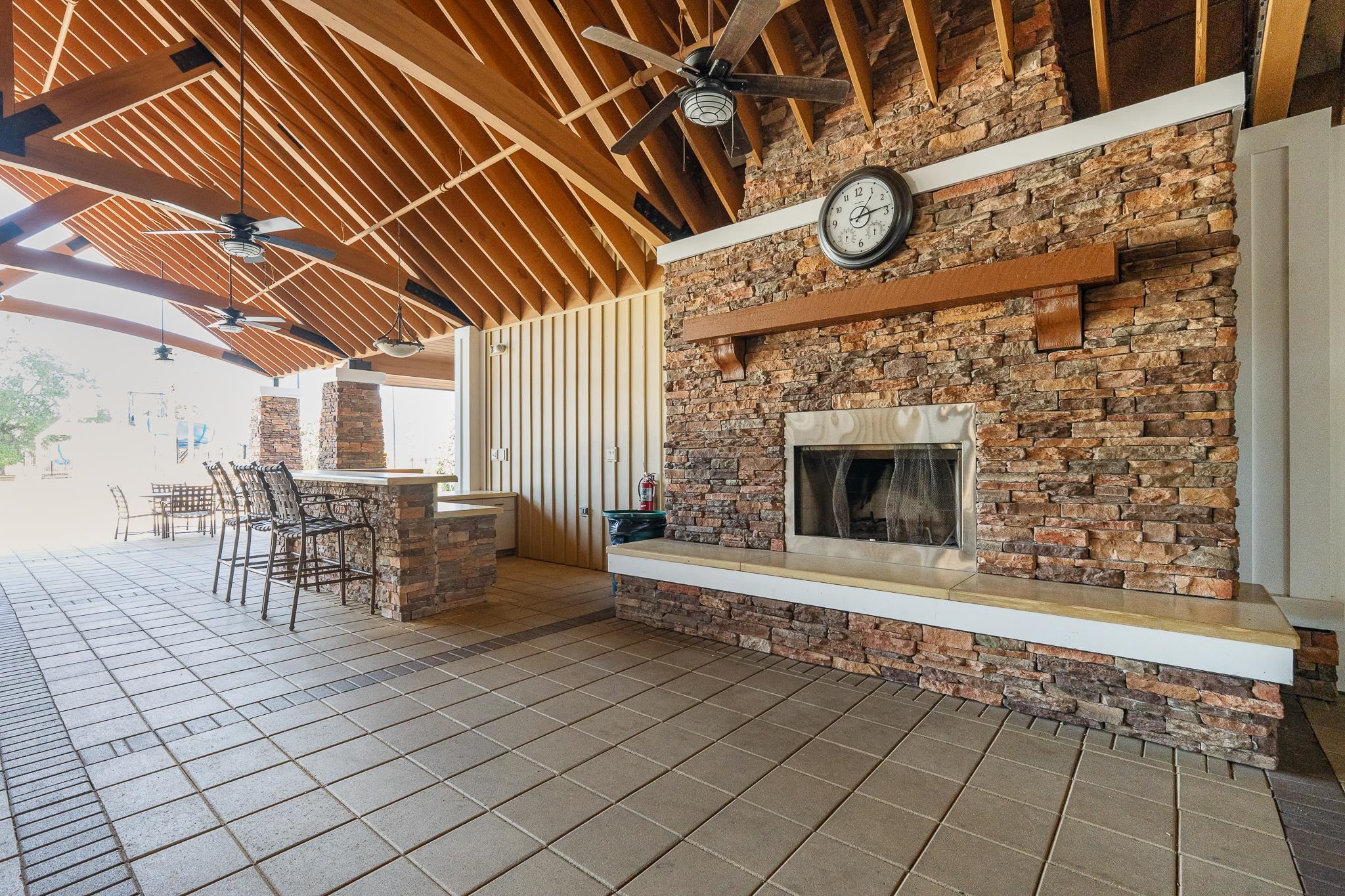1353 Camp Ridge Lane Middleburg, FL 32068 - Photo 60 of 88 View of patio / terrace featuring a ceiling fan, exterior bar, and an outdoor stone fireplace