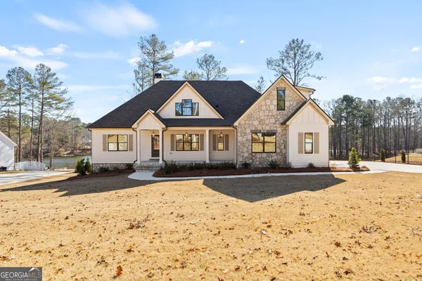a front view of a house with a yard covered in snow
