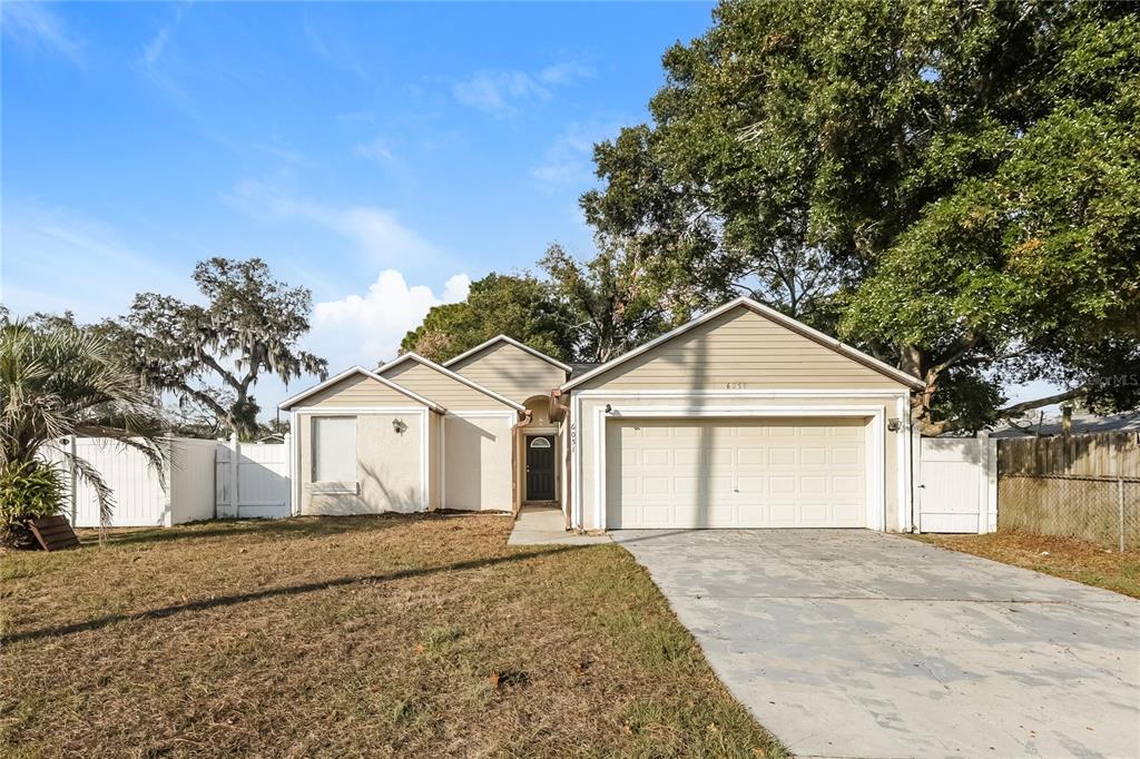 6051 Kentucky Avenue New Port Richey, FL 34653 - Photo 1 of 1 a white house with a large tree in front of it
