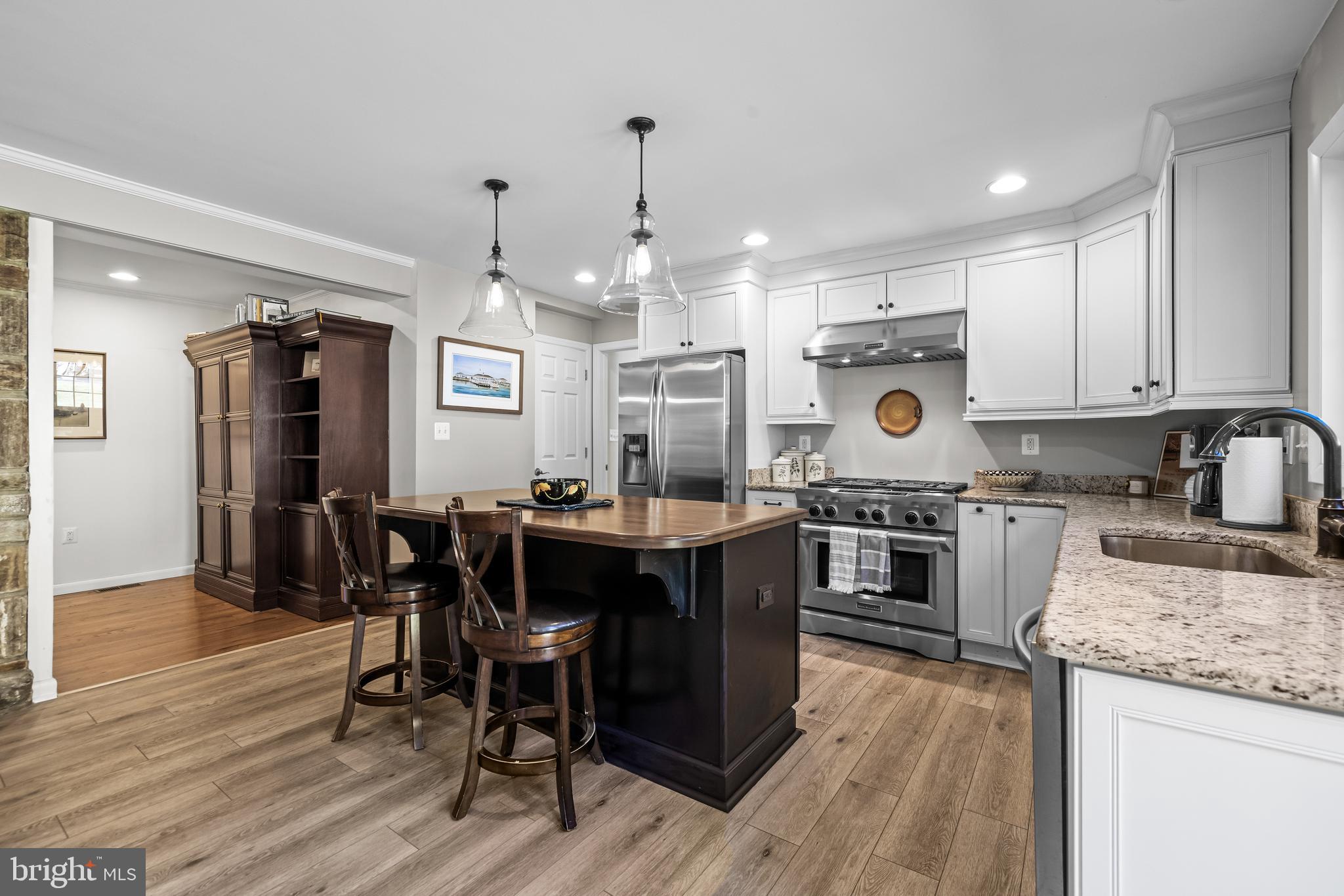 1806 Roland Avenue Ruxton, MD 21204 - Photo 11 of 43 a kitchen with kitchen island granite countertop a sink cabinets and wooden floor