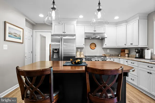 a kitchen with a stove a refrigerator and a dining table
