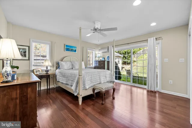 a bedroom with a bed a dresser and wooden floor