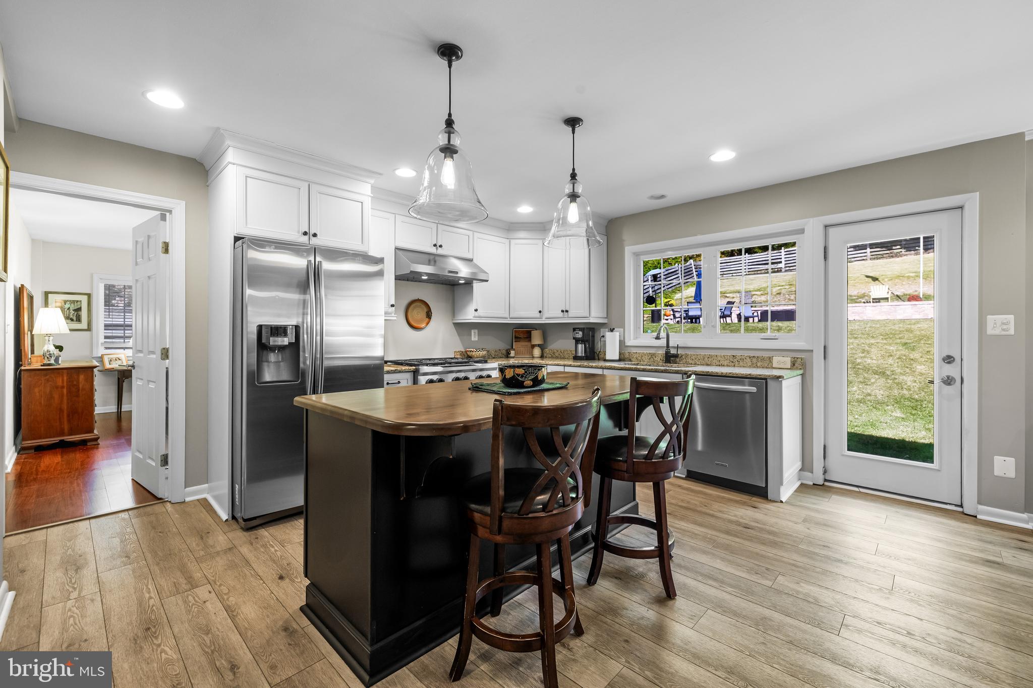 1806 Roland Avenue Ruxton, MD 21204 - Photo 10 of 43 a kitchen with stainless steel appliances granite countertop a refrigerator a sink dishwasher a stove and a dining table with wooden floor