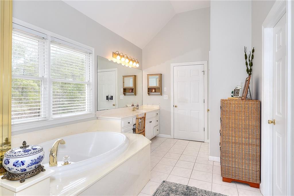 2018 Paper Birch Cove Grayson, GA 30017 - Photo 26 of 48 a bathroom with a tub a sink and a large mirror