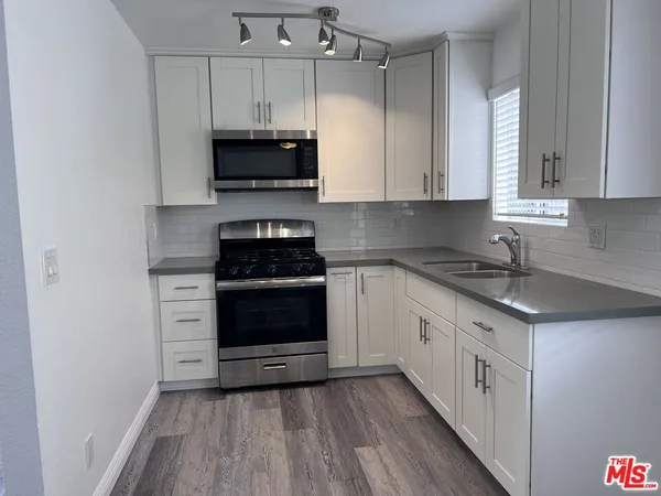 a kitchen with stainless steel appliances a stove a microwave and cabinets