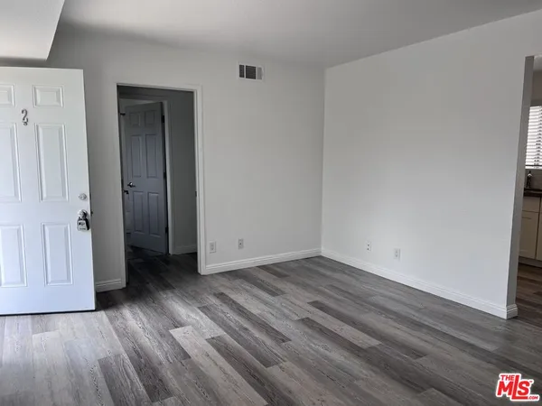 a view of a room with wooden floor and white doors