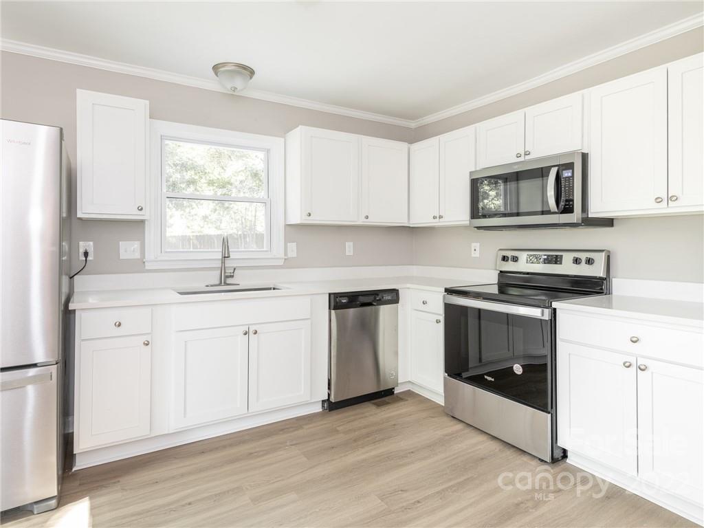 826 McAlway Road Charlotte, NC 28211 - Photo 17 of 30 a kitchen with stainless steel appliances white cabinets a sink a stove a microwave and cabinetry