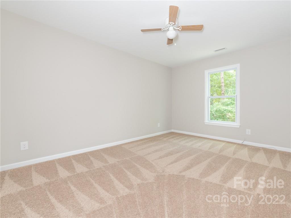 826 McAlway Road Charlotte, NC 28211 - Photo 26 of 30 an empty room with a window and a ceiling fan