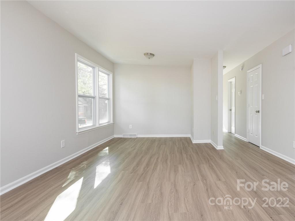 826 McAlway Road Charlotte, NC 28211 - Photo 5 of 30 an empty room with wooden floor and windows