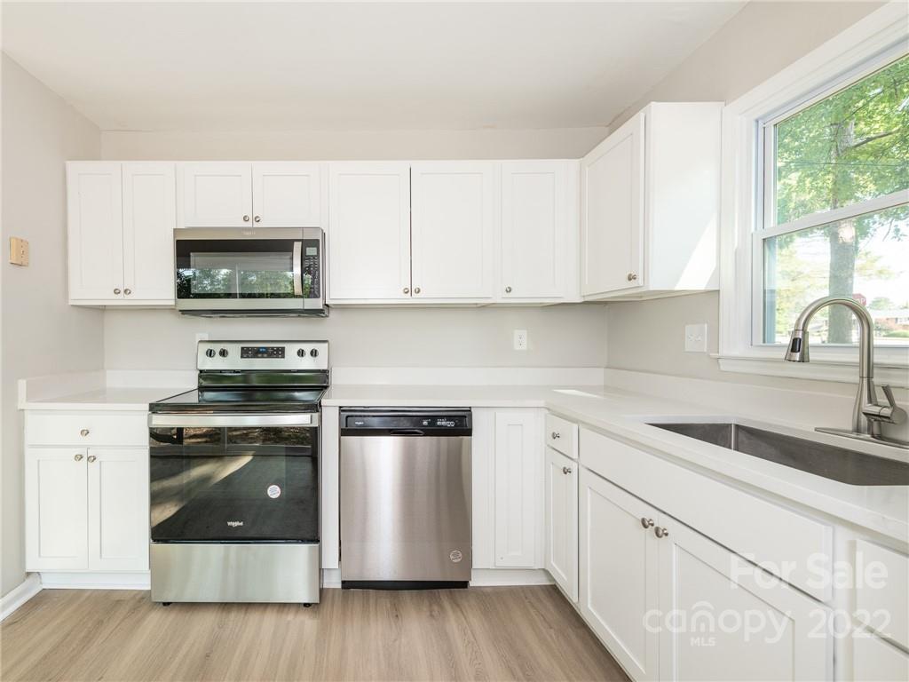 826 McAlway Road Charlotte, NC 28211 - Photo 7 of 30 a kitchen with granite countertop a stove a sink and a microwave