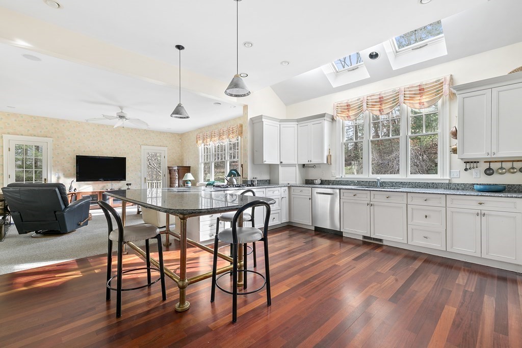 59 Crestview Road Milton, MA 02186 - Photo 6 of 32 a kitchen with stainless steel appliances granite countertop a stove a sink dishwasher a refrigerator with a dining table and chairs with wooden floor