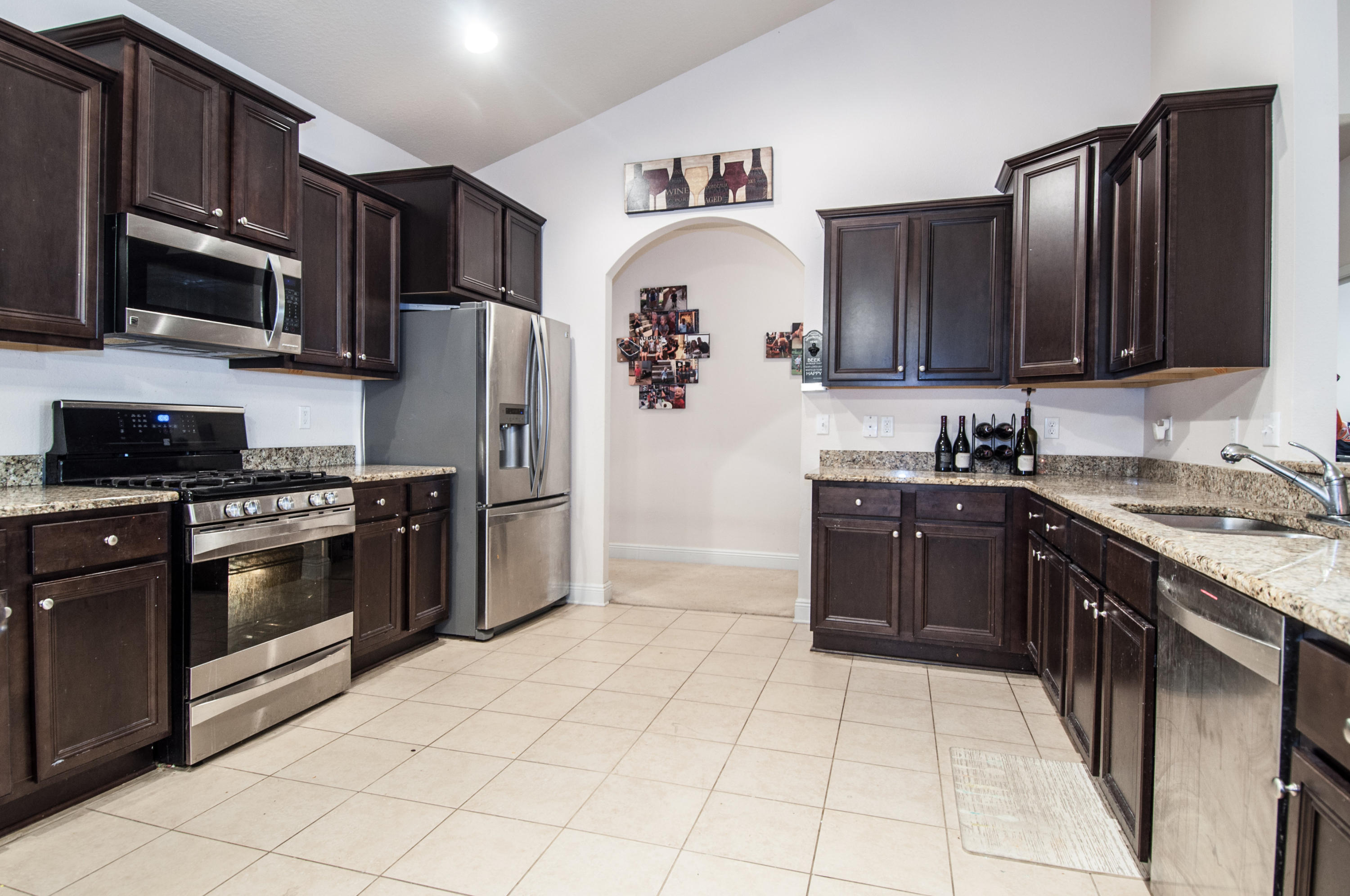 93 Mango Lane Freeport, FL 32439 - Photo 11 of 45 a kitchen with stainless steel appliances granite countertop a stove top oven a sink dishwasher a refrigerator and a microwave
