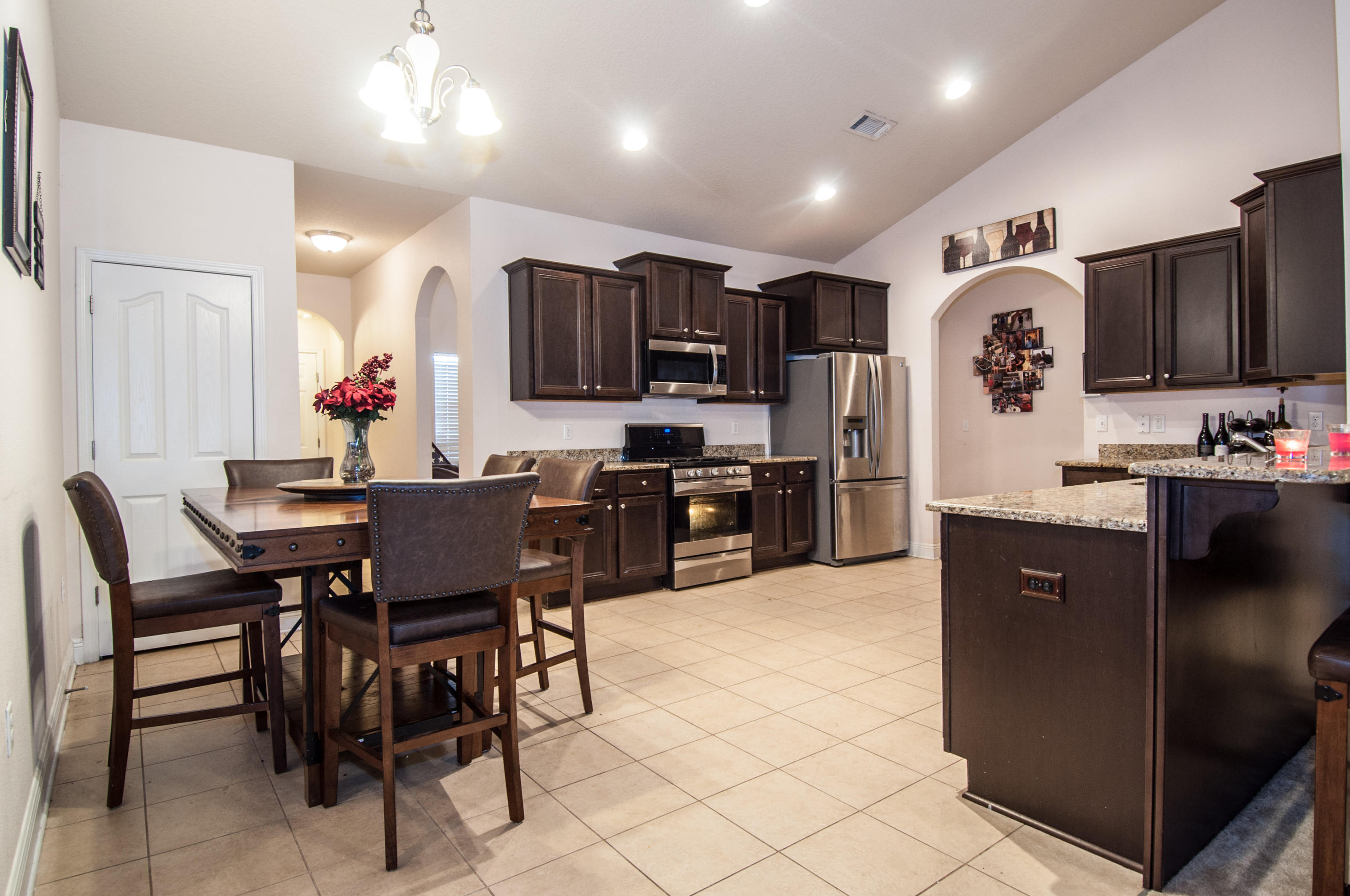 93 Mango Lane Freeport, FL 32439 - Photo 6 of 45 a kitchen with stainless steel appliances kitchen island granite countertop a refrigerator a stove a sink a dining table and chairs